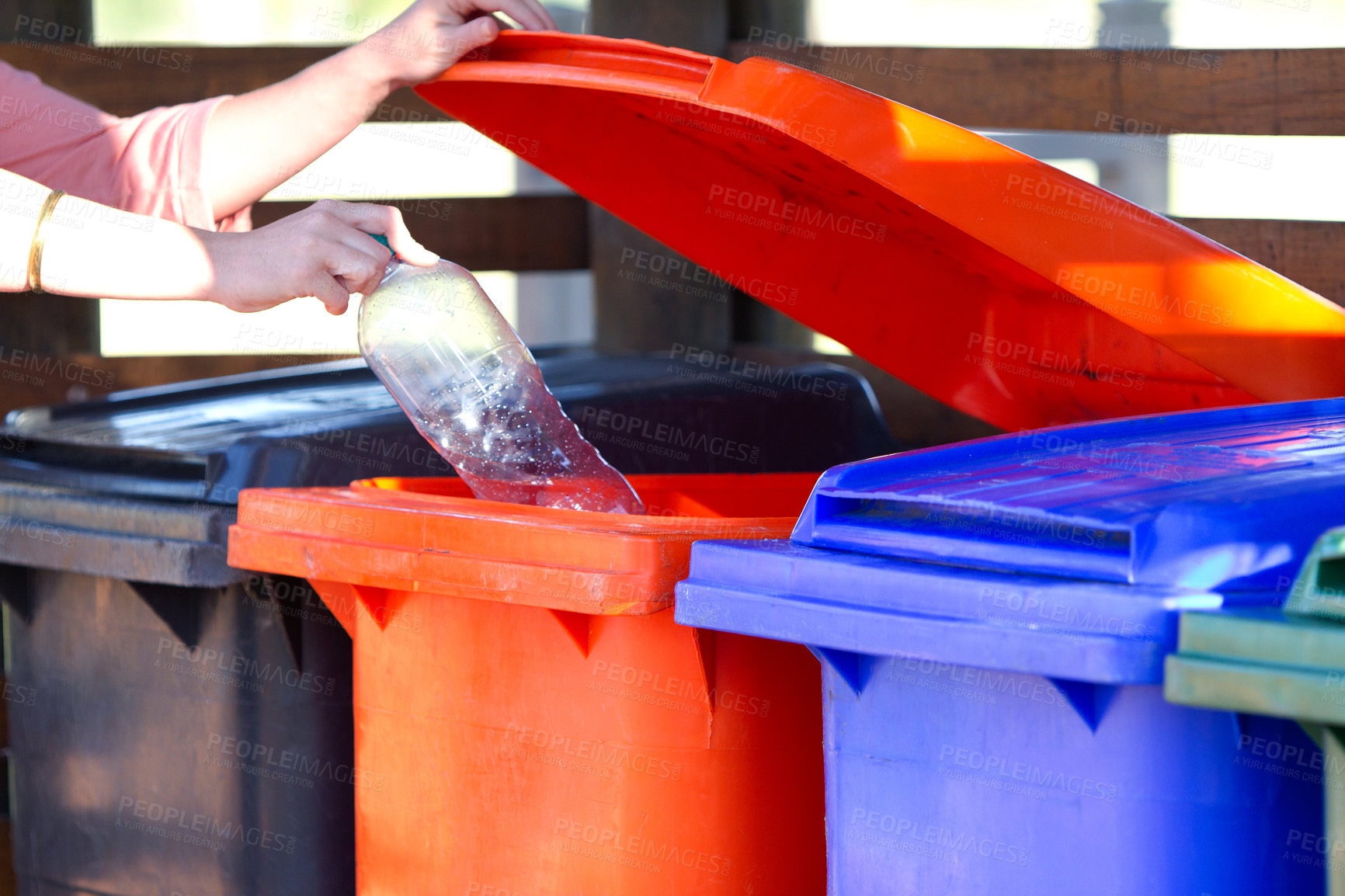 Buy stock photo Cropped shot of a person disposing of an empty bottle