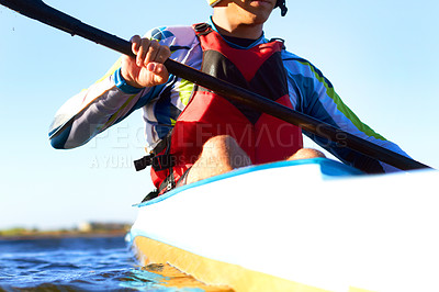 Buy stock photo Fitness, kayak and a man rowing in the water of a river alone outdoor in nature during summer adventure. Sports, exercise and training with a male athlete in a canoe to row using paddles outside