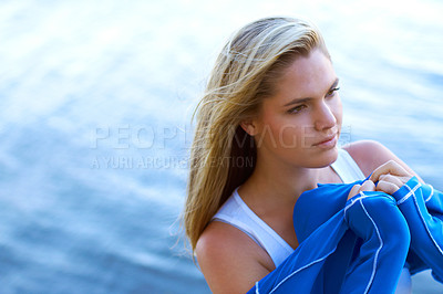 Buy stock photo Shot of a young woman putting on a wetusit