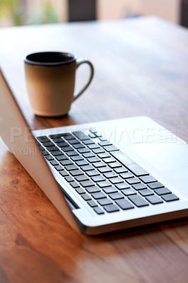 Buy stock photo Shot of a laptop and coffee mug on a table