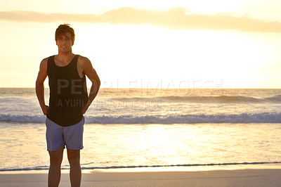 Buy stock photo Portrait, mockup and a man on the beach at sunset standing on sand by the sea at the coast outdoor. Nature, water and travel with a handsome young male tourist at the ocean during holiday or vacation