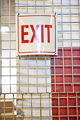 Buy stock photo Exit, safety or warehouse with a sign on factory cage in a small business for storage or workplace. Industrial background, words and gate with info, notice or poster for emergency warning or escape