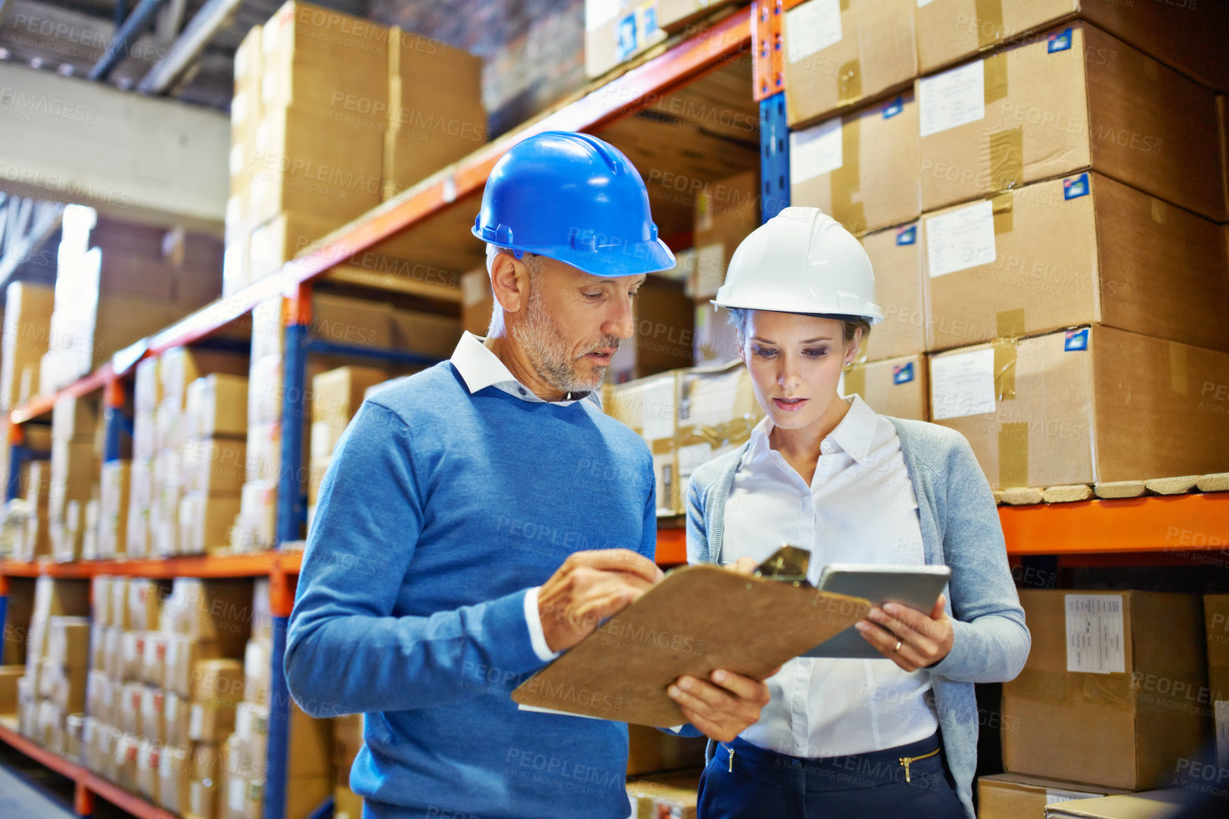 Buy stock photo Shot of two people doing an inventory check in a warehouse