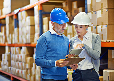 Buy stock photo Shot of two people doing an inventory check in a warehouse