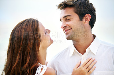 Buy stock photo Couple, outdoor and smile with love, sky and eye contact on summer holiday with connection in nature. Man, woman and trust for bonding, romance or relationship with memory on vacation in Mykonos