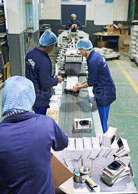 Buy stock photo Shot of a people working inside a printing, packaging and distribution factory. The commercial designs displayed represent a simulation of a real product and have been changed or altered enough by our team of retouching and design specialists so that they don't have any copyright infringements