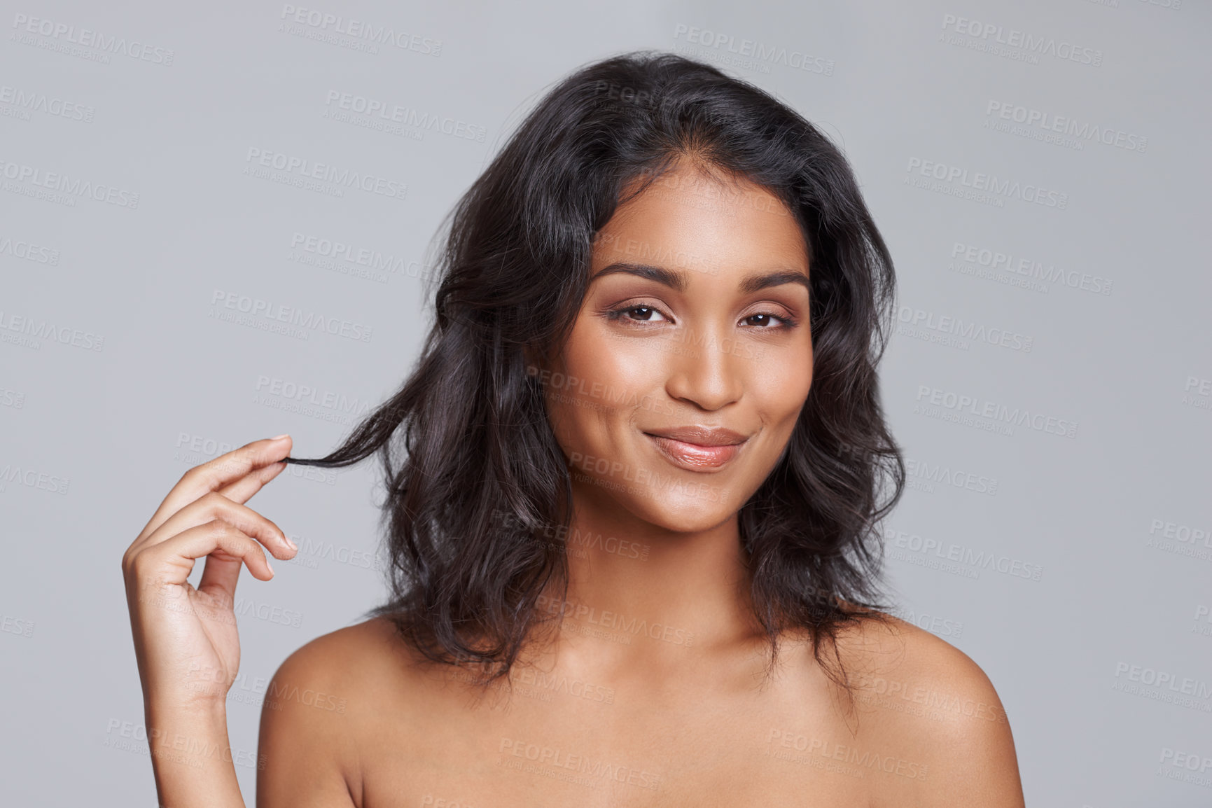 Buy stock photo Portrait, beauty and hair with a woman in studio on a gray background for natural hair treatment. Face, skin care and shampoo with a young Indian female model at the salon for a haircut or cosmetics