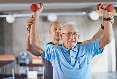 Buy stock photo Shot of a physiotherapist helping a senior man with weights