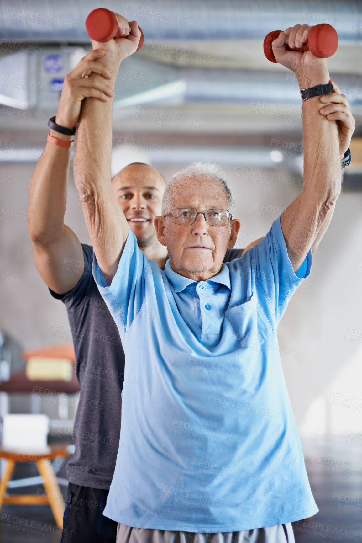 Buy stock photo Shot of a physiotherapist helping a senior man with weights