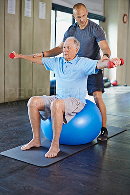 Buy stock photo Physiotherapist, helping and senior man with weights, training and elderly support for care. Men, gym and exercise for health, wellness and coaching with yoga ball for mature rehab and wellbeing