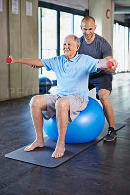 Buy stock photo Physiotherapist, helping and senior man with dumbbell, training and elderly support for care. Men, gym and exercise for health, wellness and coaching with yoga ball for mature rehab and wellbeing