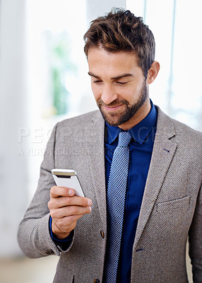 Buy stock photo Business man, phone and typing an email in office, communication and networking for company. Male person, smile and reading a notification on app for conversation, website and internet for info