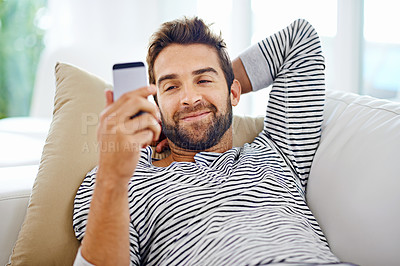Buy stock photo Man looking at his cellphone at home