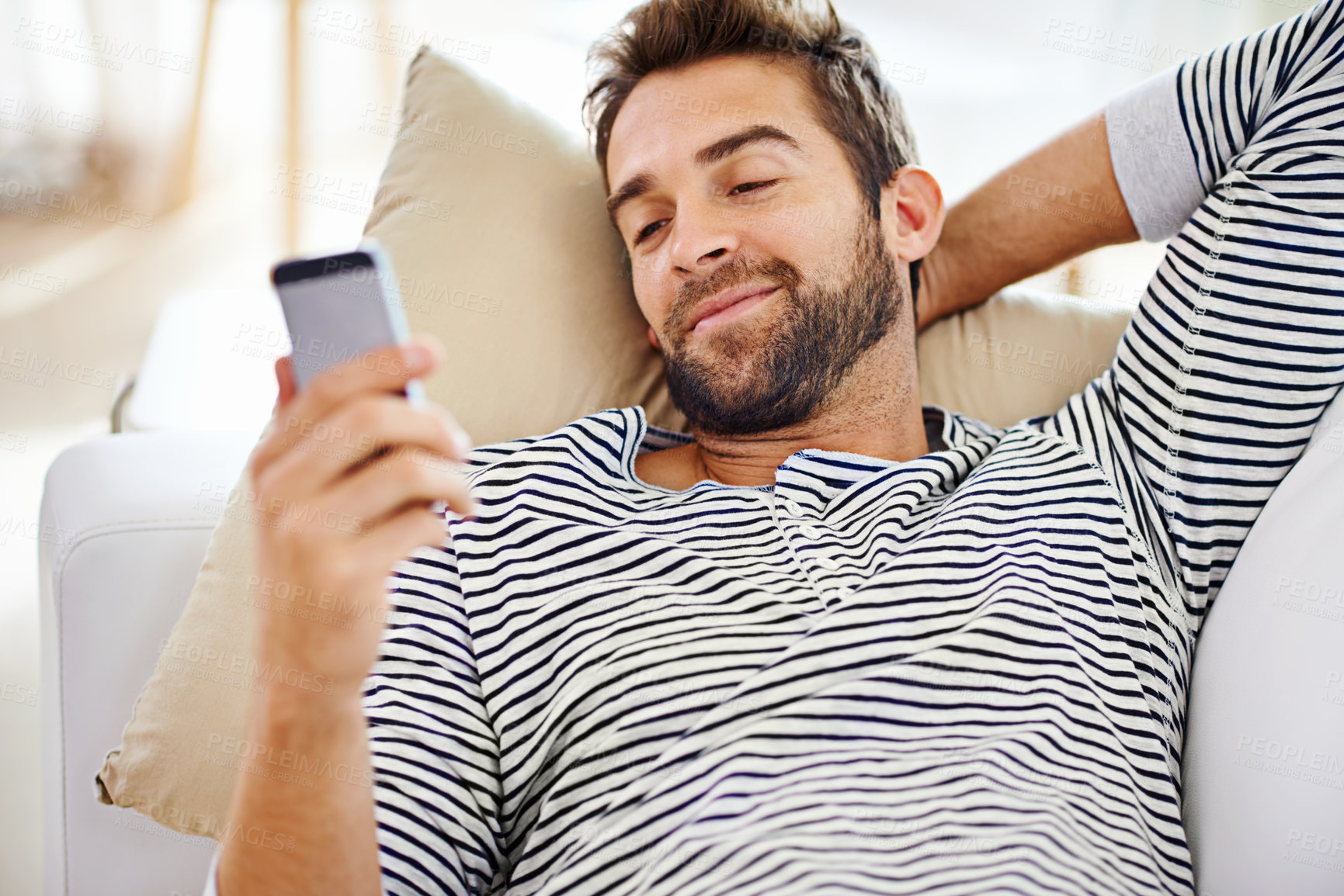 Buy stock photo Man, smile and smartphone on sofa in living room for for communication, social media and or texting. Cellphone, happy and male person for internet browsing, notification or online chat on weekend