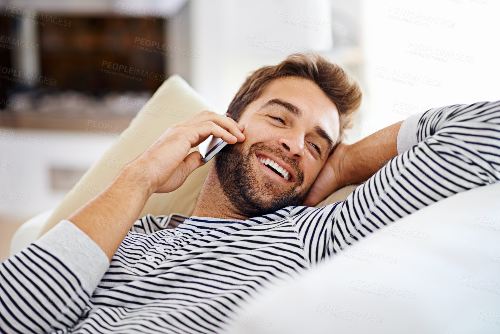 Buy stock photo Happy man, relax or phone call in home talking or speaking in living room for communication or chat. Smile, peace or person laughing in a mobile conversation on couch or sofa in a house for a break