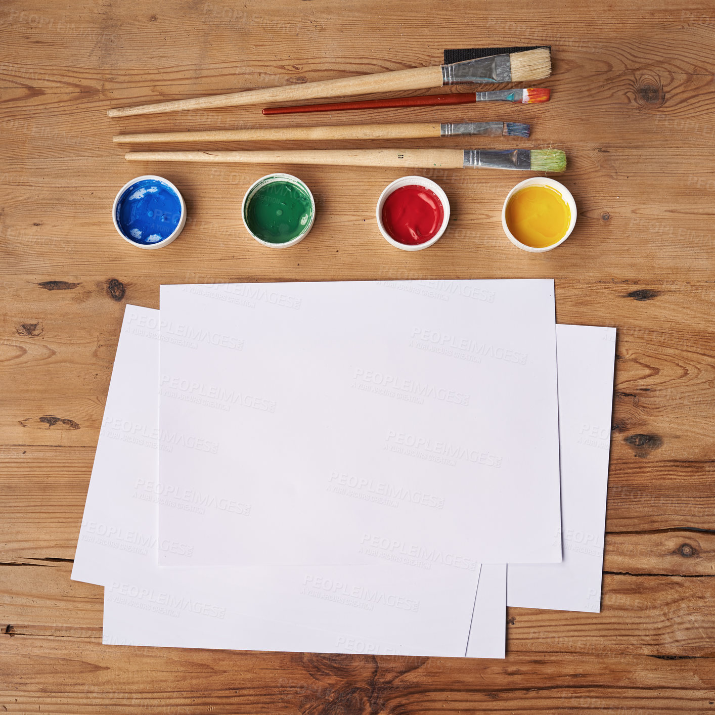 Buy stock photo Art, painting and creative supplies on a wooden desk with paper from above. Paintbrushes, colors and still life containers ready to create artwork or an artistic design in studio with copy space