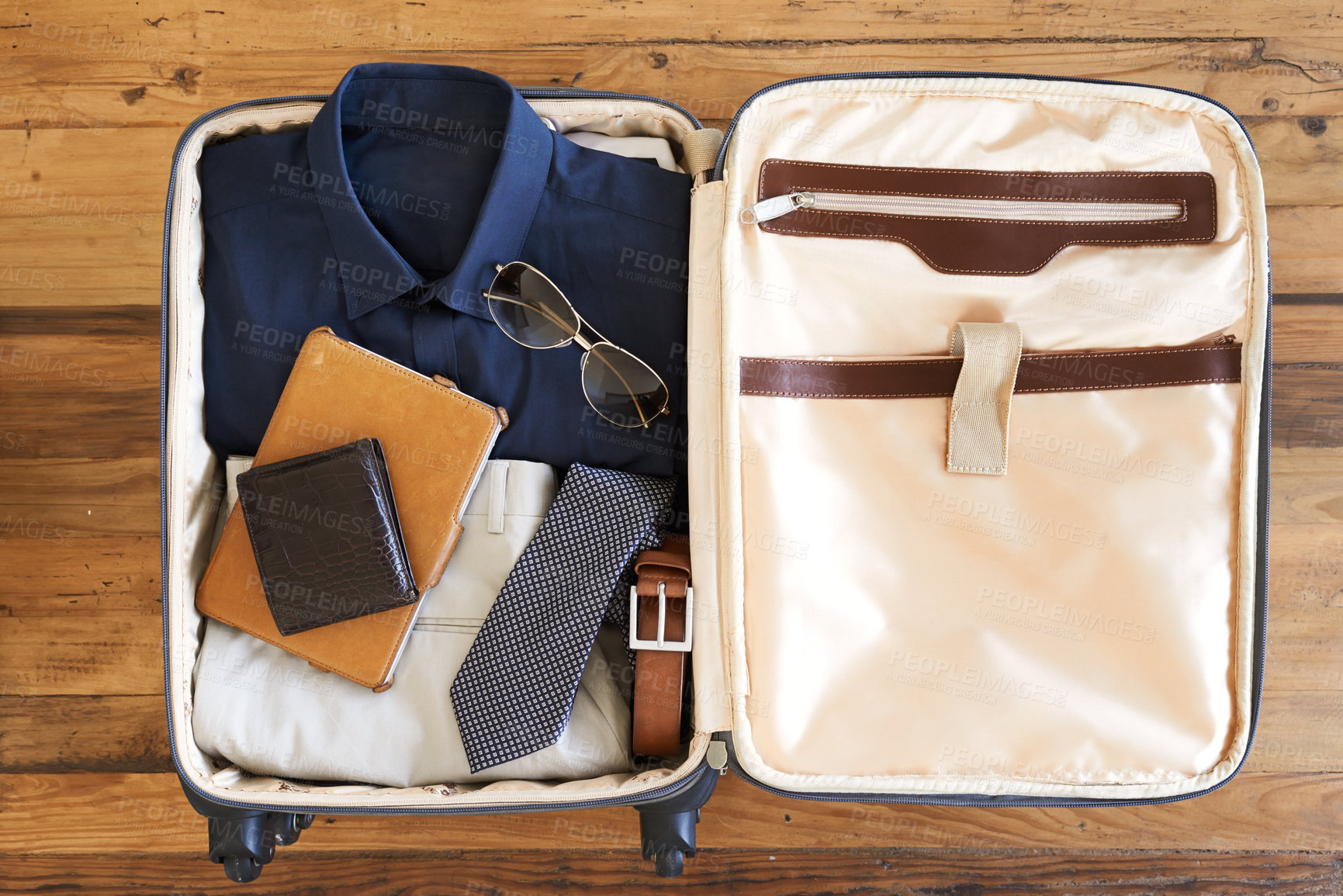 Buy stock photo High angle shot of a suitcase packed with various essentials for a traveling businessman