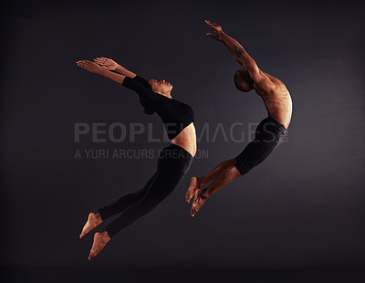 Buy stock photo A female and male contemporary dancer performing a dramatic pose in front of a dark background