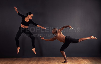 Buy stock photo Dancers, dramatic and performance in studio with dark background, male and female ballerina being creative together. Athletics, competitive and sports for fitness, diverse people, art and movement.