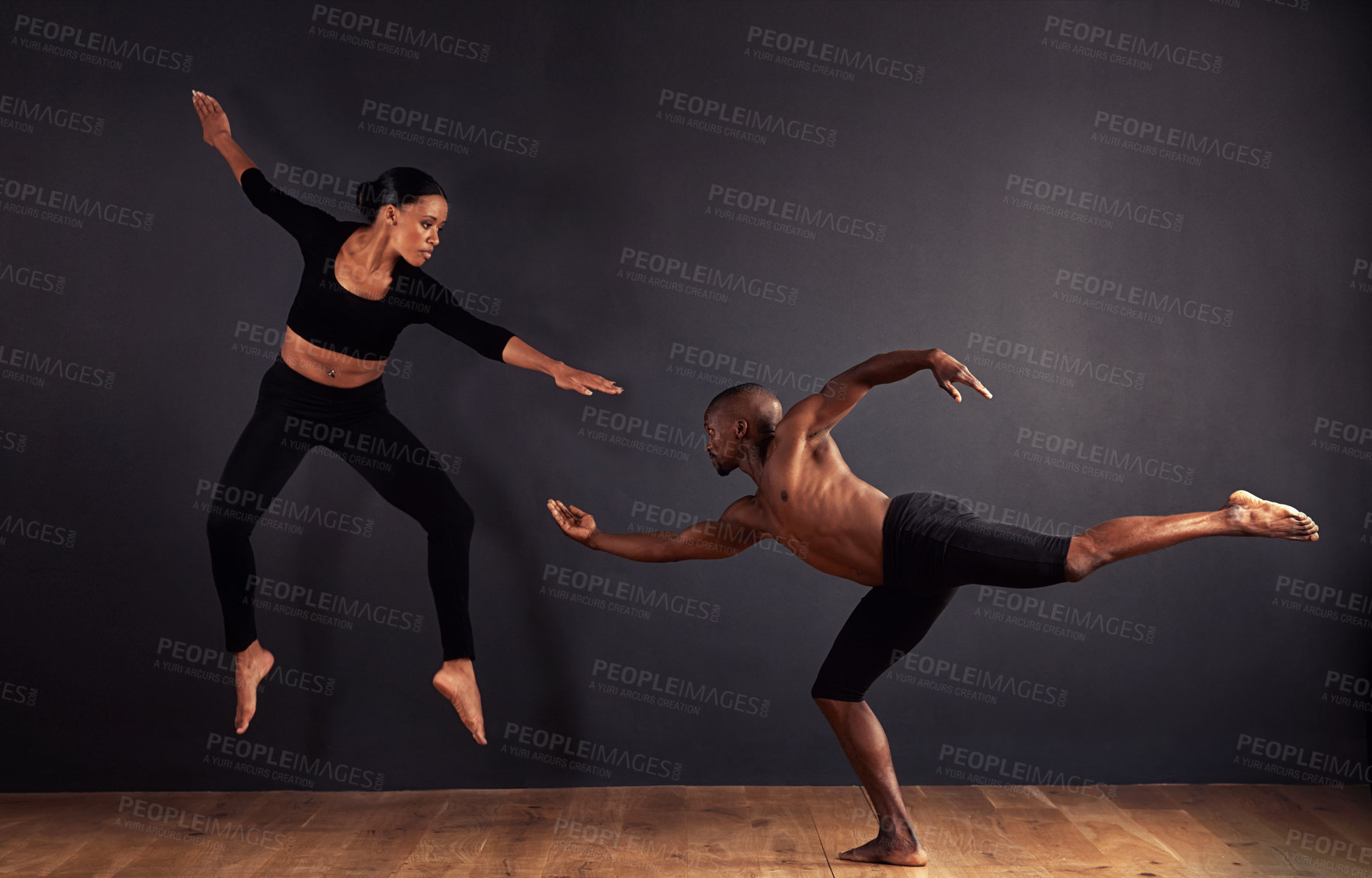 Buy stock photo Dancers, dramatic and performance in studio with dark background, male and female ballerina being creative together. Athletics, competitive and sports for fitness, diverse people, art and movement.
