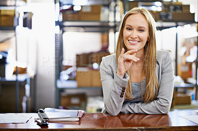 Buy stock photo Portrait of a young woman standing at a counter in a warehouse