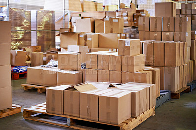 Buy stock photo Shot of stacked boxes in a large distribution warehouse