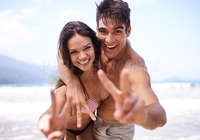 Buy stock photo Love, peace sign and portrait of couple at beach for tropical holiday adventure, relax or bonding together. Nature, happy man and woman on romantic date with ocean, blue sky and smile on fun vacation