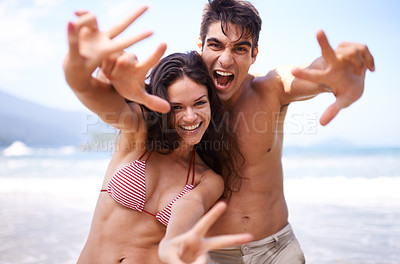 Buy stock photo Love, peace sign and portrait of couple at ocean for tropical holiday adventure, relax or bonding together. Nature, happy man and woman on romantic date with beach, blue sky and smile on fun vacation