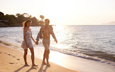 Buy stock photo Love, sunset and couple walking at beach for tropical holiday adventure, relax and bonding together. Nature, man and woman on romantic date with ocean, island and evening waves on happy vacation.