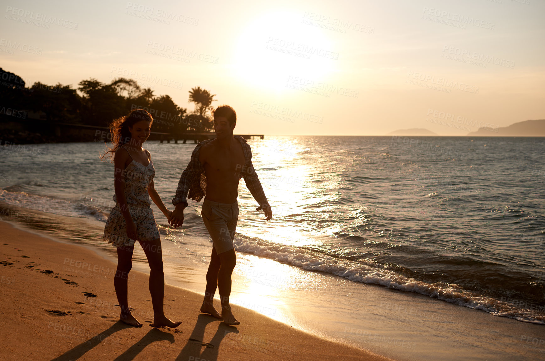 Buy stock photo Love, sunset sky and couple walking at ocean for tropical holiday adventure, relax and bonding together. Nature, man and woman on romantic date with beach, island and evening waves on happy vacation.