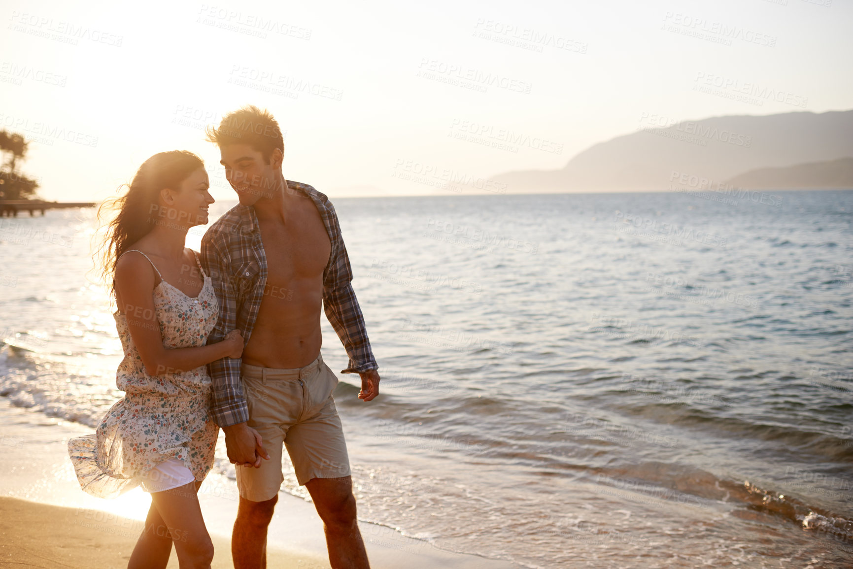 Buy stock photo Love, waves and happy couple walking at ocean for tropical holiday adventure, relax and bonding together. Nature, man and woman on romantic date with beach, sunset sky and connection on vacation.