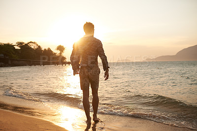 Buy stock photo Man, walking on beach and ocean with sunset, lens flare with back view and waves on vacation in Hawaii. Tourism, travel and adventure with peace, zen and fresh air for wellness, summer and sunshine