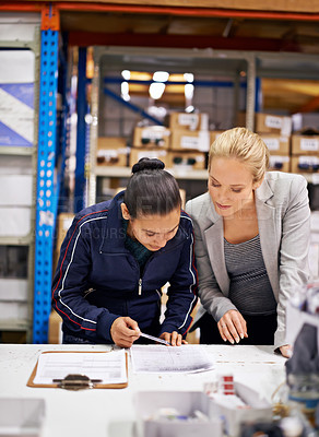 Buy stock photo Cropped shot of a young woman and her boss doing stock take in a warehouse