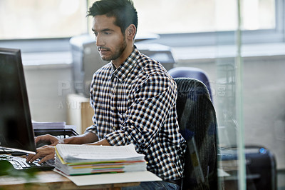Buy stock photo Cropped shot of a handsome young designer working on a pc
