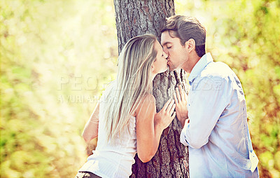 Buy stock photo Couple, kiss and love by tree for romance, affection or love in nature, outdoor park or forest. Young man and woman kissing for embrace, relationship or bonding intimacy in woods for date or freedom