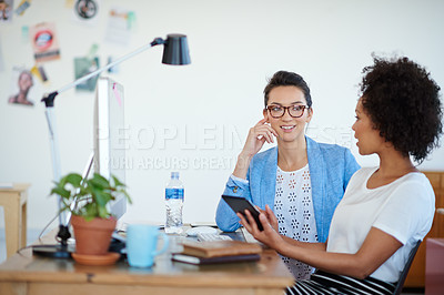 Buy stock photo Shot of an attractive young woman sitting at her workstation in the office. The commercial designs displayed represent a simulation of a real product and have been changed or altered enough by our team of retouching and design specialists so that they don't have any copyright infringements