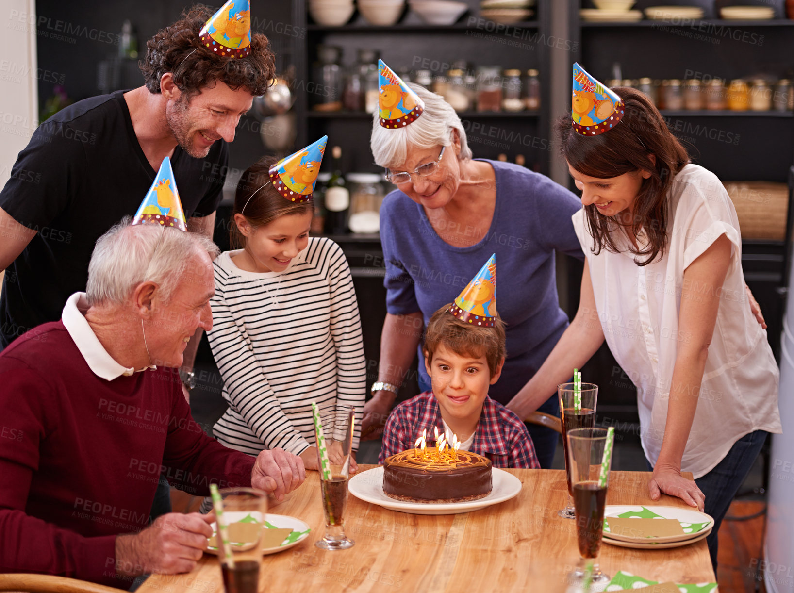 Buy stock photo Family, birthday cake and restaurant with boy, parents and grandparents together with fun and candles. Happy, smile and dessert with children and celebration with event food and party hats at a table