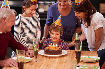 Buy stock photo Family, birthday cake and smile of boy, parents and grandparents together with youth and candles. Happy, kid and dessert with children and celebration with event food and party hats at a table