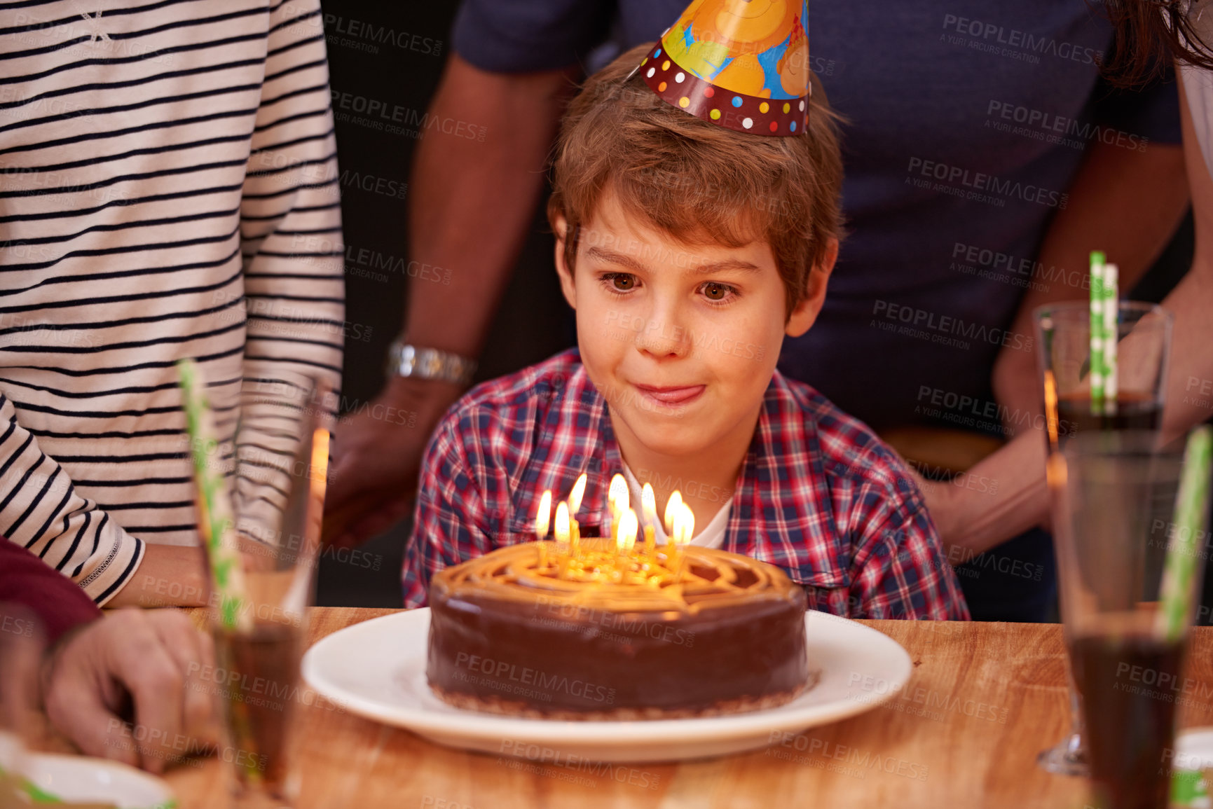 Buy stock photo Excited, child and candles on birthday cake at party in celebration and hungry for food on table. Happy, kid and family together at event to relax and enjoy growth development of boy in home