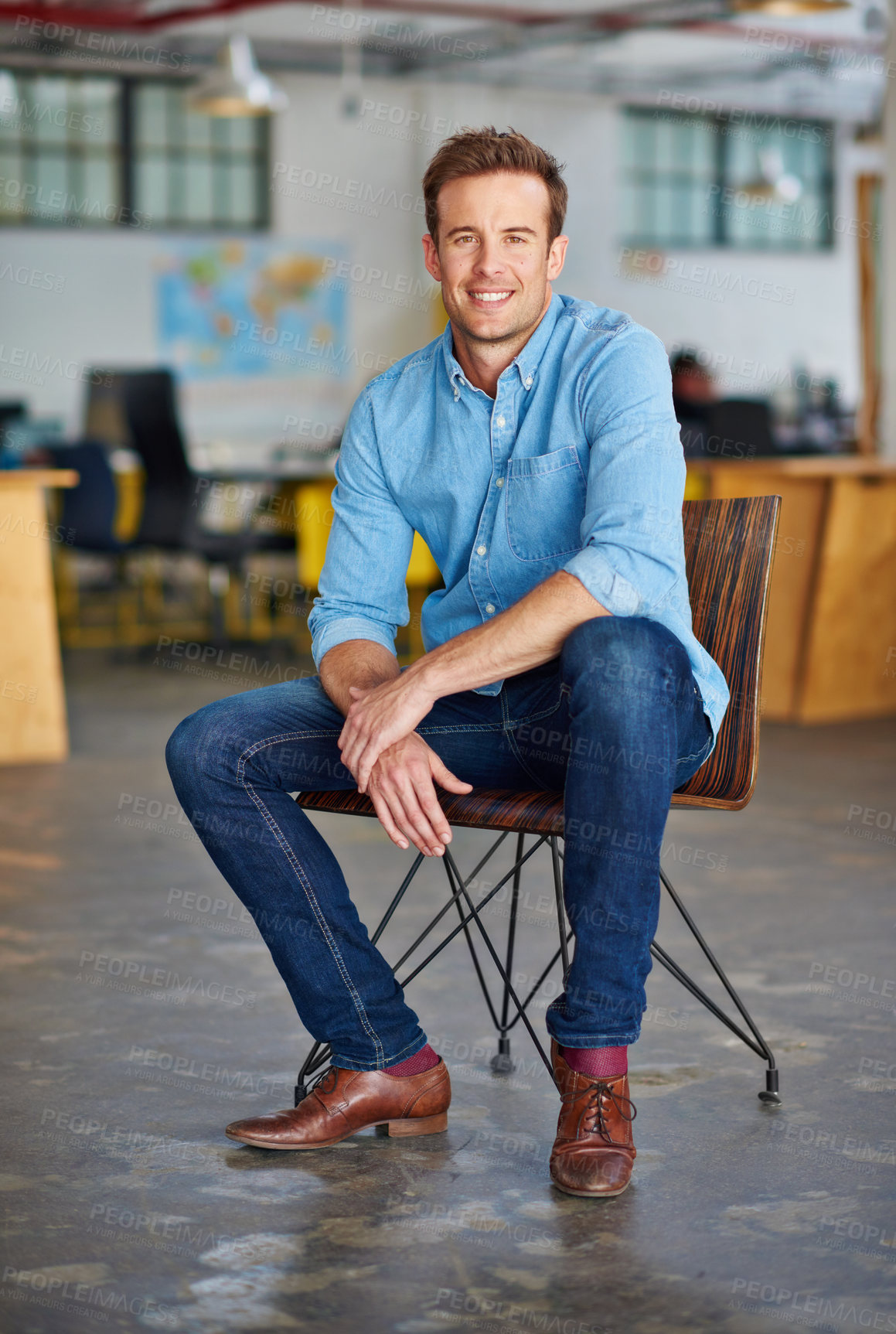 Buy stock photo Portrait of a handsome young designer sitting on a chair in an office