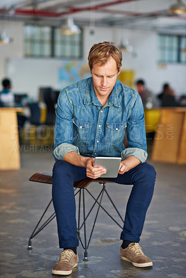 Buy stock photo Portrait of a handsome young man using a digital tablet in an office