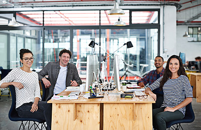 Buy stock photo Portrait of a group of young office workers sitting at their work stations