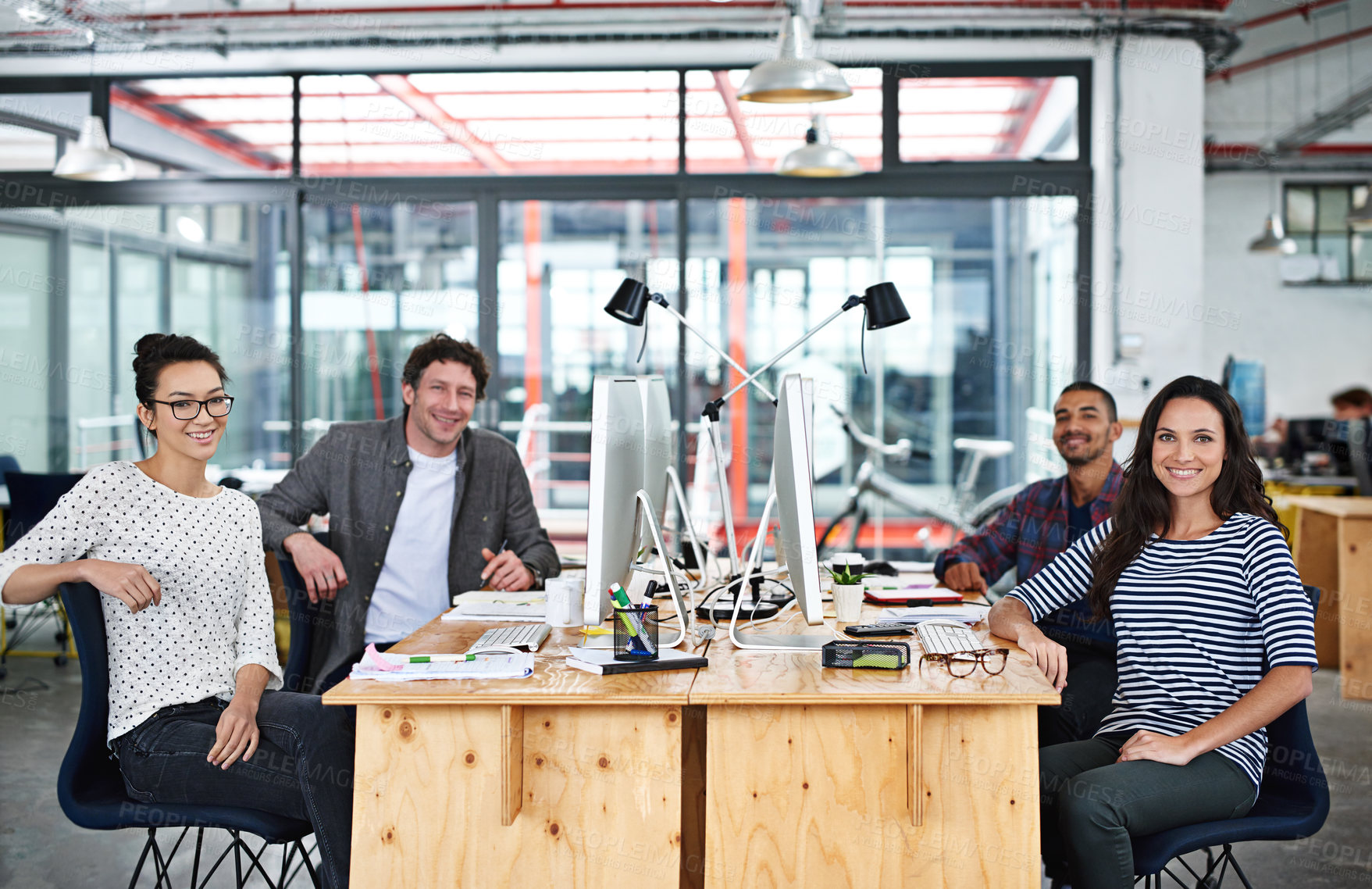 Buy stock photo Portrait of a group of young office workers sitting at their work stations