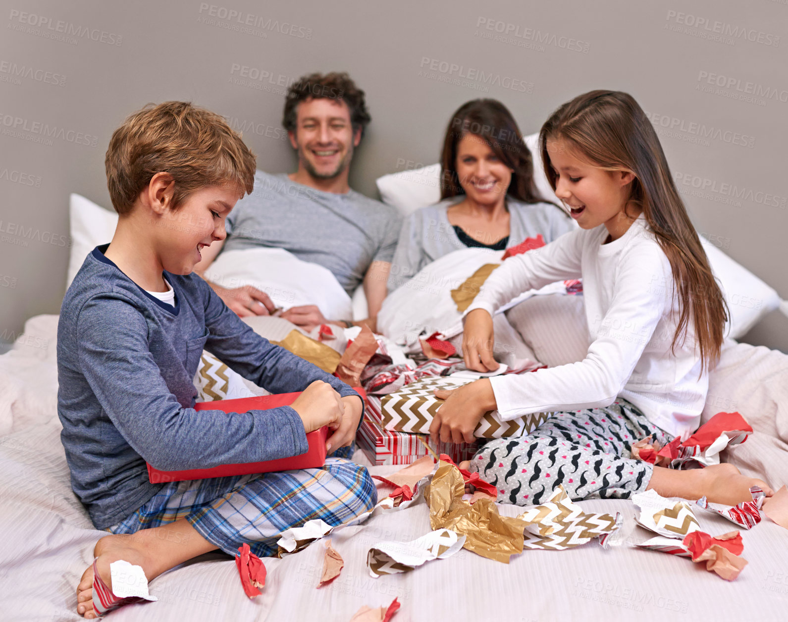 Buy stock photo Shot of a happy family of four in the bedroom