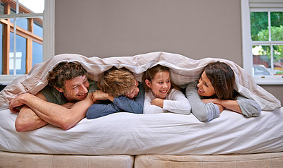 Buy stock photo Bedroom, blanket and parents with children, family and happiness with smile and bonding together. Home, cover and mother with father and siblings with kids and weekend break with vacation and morning