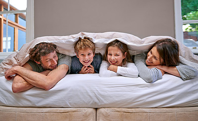 Buy stock photo Shot of a happy family of four in the bedroom