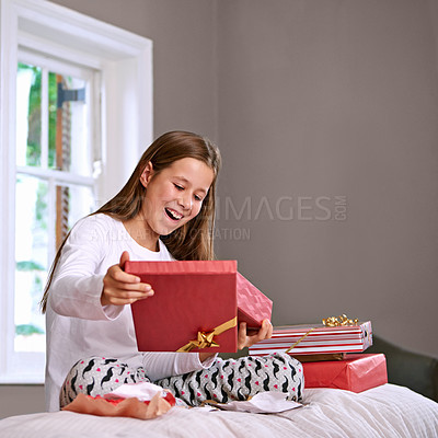 Buy stock photo Shot of an excited young girl opening her birthday gifts