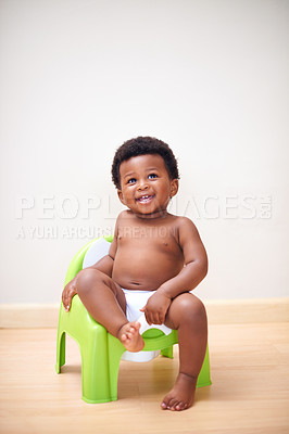 Buy stock photo Shot of an adorable baby boy sitting on a potty training seat
