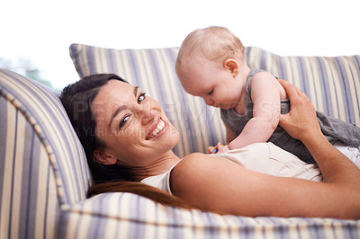 Buy stock photo Portrait of an attractive young woman and her baby girl lying on the sofa