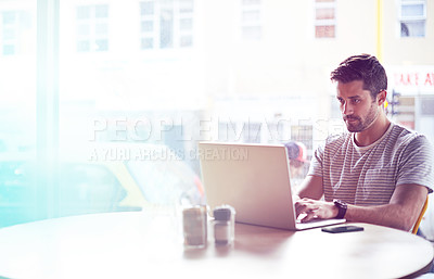 Buy stock photo Young man, cafe and typing with laptop for communication, social media or networking at indoor restaurant. Male person, freelancer or remote work on computer for research or reading at coffee shop